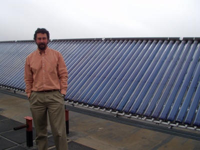Professor Andrea Mammoli and solar collectors on the UNM Mechanical Engineering Building